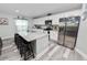 Bright and open kitchen with gray wood-look floors, stainless steel appliances, and granite countertops at 3425 Sutton Ridge St, Lakeland, FL 33810