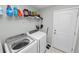 Bright laundry room with washer, dryer, and built-in storage shelves at 3425 Sutton Ridge St, Lakeland, FL 33810