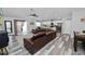 Open concept living room featuring wood-look flooring, comfortable leather furniture, and a view of the kitchen at 3425 Sutton Ridge St, Lakeland, FL 33810