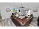 Spacious living room with gray wood-look floors, a large TV, and a comfortable leather sectional sofa at 3425 Sutton Ridge St, Lakeland, FL 33810