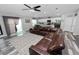 Cozy living room features a comfortable leather sectional sofa, leading to an outdoor patio with natural light at 3425 Sutton Ridge St, Lakeland, FL 33810