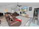 Open-concept living room with wood-look floors, leather sofas, and seamless flow to the dining and entryway at 3425 Sutton Ridge St, Lakeland, FL 33810