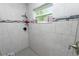 Tiled shower featuring gray tiling, mosaic accents, a window, and a built-in shelf at 3425 Sutton Ridge St, Lakeland, FL 33810