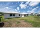 The backyard features green grass and mature trees and a clean white exterior at 3570 Milano Ave # 3570, Lakeland, FL 33803