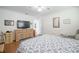 Bright bedroom features a large TV atop a wooden dresser and a cozy bed with a patterned comforter at 3570 Milano Ave # 3570, Lakeland, FL 33803