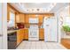 Functional kitchen with oak cabinets, white appliances, tile floors, and view of the adjacent dining area at 3570 Milano Ave # 3570, Lakeland, FL 33803