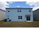 Exterior rear of a two-story home with blue siding, various windows, and a sliding glass door at 3882 Resting Robin Ave, Bartow, FL 33830
