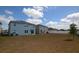 Wide view of the home's expansive backyard, adjacent to a blue two-story house at 3882 Resting Robin Ave, Bartow, FL 33830