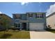 Charming two-story home features a blue exterior, well-maintained lawn, and a two-car garage at 3882 Resting Robin Ave, Bartow, FL 33830