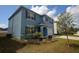 Side view of blue two-story home with landscaped front yard and two car garage on a sunny day at 3882 Resting Robin Ave, Bartow, FL 33830