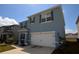 Lovely two-story blue home with a two-car garage and manicured landscaping on a bright, sunny day at 3882 Resting Robin Ave, Bartow, FL 33830