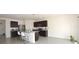 Modern kitchen with stainless steel appliances, dark cabinetry, and a granite island at 3882 Resting Robin Ave, Bartow, FL 33830
