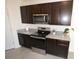 Stylish kitchen with dark cabinets, stainless steel appliances, and granite countertops at 3882 Resting Robin Ave, Bartow, FL 33830