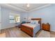 Well-lit bedroom with wood bedframe, soft blue color palette, and lake view window at 3923 Serenade Ln # 426, Lakeland, FL 33811