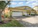 Charming yellow home with a three-car garage and brick-paved driveway at 3923 Serenade Ln # 426, Lakeland, FL 33811