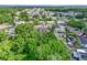 Aerial view of home surrounded by mature trees in a quiet neighborhood at 407 Ne 8Th St, Mulberry, FL 33860