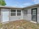 Exterior rear corner with multiple windows, siding, and a light and dark entry door at 407 Ne 8Th St, Mulberry, FL 33860