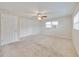 Bedroom featuring a ceiling fan, large windows and closet with bi-fold doors at 407 Ne 8Th St, Mulberry, FL 33860