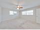 Bedroom with neutral carpet, a ceiling fan, and windows providing natural light at 407 Ne 8Th St, Mulberry, FL 33860