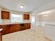 This kitchen features tile floors, dark cabinetry, laminate countertops and an open view to the dining room at 407 Ne 8Th St, Mulberry, FL 33860