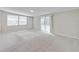 A bright living room features plush carpeting, neutral paint, and sliding glass doors at 407 Ne 8Th St, Mulberry, FL 33860
