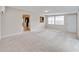 A spacious living room offers plush carpeting, neutral paint, and a view to the kitchen at 407 Ne 8Th St, Mulberry, FL 33860