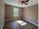 Bedroom with a ceiling fan, wood-look laminate flooring, neutral walls, and a window at 4189 Radford Rd, Bartow, FL 33830