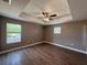 Spacious bedroom features wood-look flooring, tray ceiling, ceiling fan and two windows allowing ample light at 4189 Radford Rd, Bartow, FL 33830