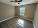 Bedroom with a ceiling fan, wood-look laminate flooring, neutral walls, and a window at 4189 Radford Rd, Bartow, FL 33830