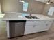 Kitchen island with stainless steel dishwasher, white cabinetry, granite countertop and a stainless steel sink at 4189 Radford Rd, Bartow, FL 33830
