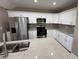 Modern kitchen with white cabinets, granite countertops, stainless steel appliances, and ample storage space at 4189 Radford Rd, Bartow, FL 33830