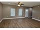 Open living room with wood-look flooring, a ceiling fan and two windows providing natural light at 4189 Radford Rd, Bartow, FL 33830