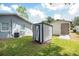 Backyard featuring sheds, lawn, and the house with grey exterior at 4215 Sunnyside Dr, Lakeland, FL 33810