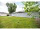 Backyard featuring a grey exterior, a white door, and a well-maintained lawn at 4215 Sunnyside Dr, Lakeland, FL 33810