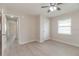 Bedroom showcases light-colored floors, a ceiling fan, a window, and neutral wall paint at 4215 Sunnyside Dr, Lakeland, FL 33810