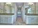 Dual sink bathroom featuring granite countertops, wood-look tile flooring, and modern lighting at 4318 Juliana Lake Dr, Auburndale, FL 33823