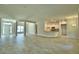Open-concept living room with wood-look tile flooring, ample natural light, and view of kitchen at 4318 Juliana Lake Dr, Auburndale, FL 33823