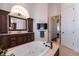 Luxurious bathroom featuring a soaking tub, a mounted television, dark wood vanity, and elegant finishes at 460 Canterwood Dr, Mulberry, FL 33860