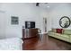 Spacious bedroom with hardwood floors, a sofa, and a large dresser beneath a wall-mounted television at 460 Canterwood Dr, Mulberry, FL 33860
