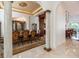 Elegant dining room boasts marble floors, ornate chandelier, and classic wood furniture for sophisticated entertaining at 460 Canterwood Dr, Mulberry, FL 33860