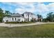 A well-manicured lawn, mature trees, and fountain create a stunning view of the home's exterior at 460 Canterwood Dr, Mulberry, FL 33860
