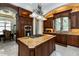 Gourmet kitchen featuring custom wood cabinetry, granite countertops, gas cooktop, and open layout at 460 Canterwood Dr, Mulberry, FL 33860