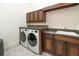 Functional laundry room featuring a washer, dryer, overhead cabinets, and a utility sink at 460 Canterwood Dr, Mulberry, FL 33860