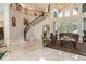 Elegant living room showcases a grand staircase, floor-to-ceiling windows, and luxurious furnishings at 460 Canterwood Dr, Mulberry, FL 33860