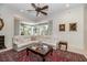 Cozy living room with white leather seating, decorative rug, and bright natural light through large windows at 460 Canterwood Dr, Mulberry, FL 33860