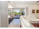 Open living area with white sofas and a view of the pool and outdoor space through large glass windows at 460 Canterwood Dr, Mulberry, FL 33860