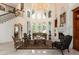 Bright and spacious living room featuring large windows, a fireplace, and a staircase with ornate iron railings at 460 Canterwood Dr, Mulberry, FL 33860