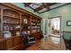 Office featuring built-in shelving, hardwood floors, and a glass topped desk at 460 Canterwood Dr, Mulberry, FL 33860