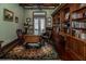Spacious home office with hardwood floors, custom built-in bookshelves, and leather furnishings at 460 Canterwood Dr, Mulberry, FL 33860