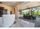 This tiled outdoor patio features a dining set, a built in grill, and views of the surrounding landscape at 460 Canterwood Dr, Mulberry, FL 33860